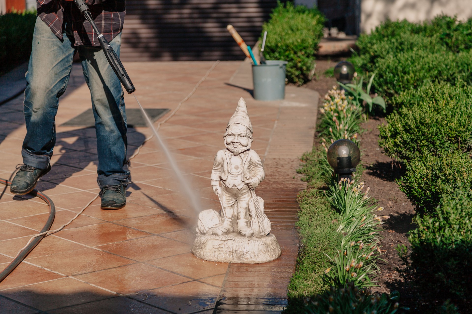 Washing garden gnome statue with special tool